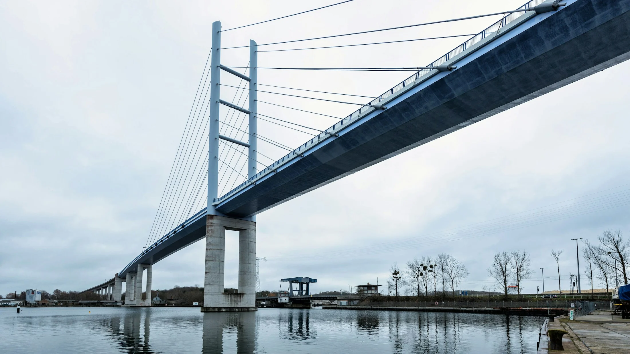 A modern cable-stayed bridge over calm water.